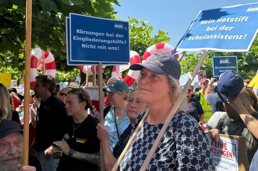 VdK-Mitglieder auf der Kundgebung „S.O.S. SOZIALSTAAT!“ Menschen halten in der Menge VdK-Plakate hoch.