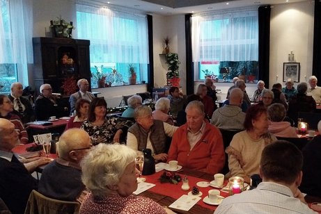 Auf dem Foto sind die G&auml;ste unser Weihnachtsfeier zu sehen, die an festlich gedeckten Tischen sitzen und der Begr&uuml;&szlig;ungsrede des OV-Vorsitzenden zuh&ouml;ren.