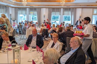 Die Teilnehmerinnen und Teilnehmer der 75-Jahr-Feier an großen runden Tischen im Grollander Krug in Bremen.