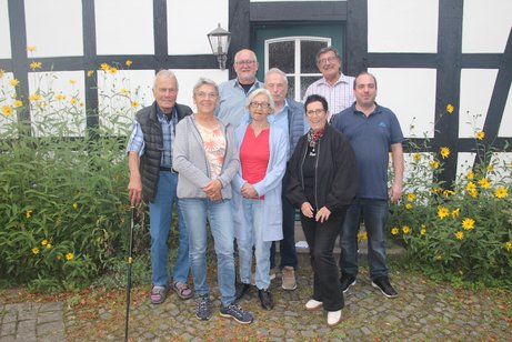 die Mitglieder des Vorstandes und die Kassenprüfer vor einem Fachwerkhaus des Dorfplatzes Hüsede