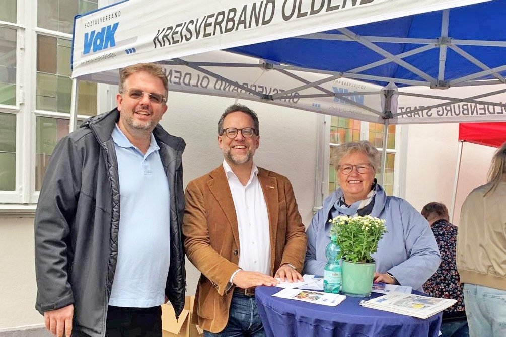Die drei Personen im blau-wei&szlig;en Messezelt.