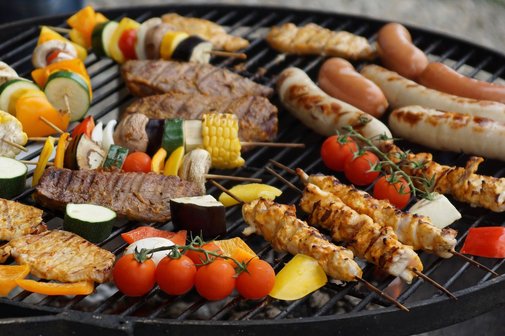 Grill mit Würstchen, Spiessen und Gemüse