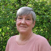 Portraitfoto von Silvia Gunkel vor einer gr&uuml;nen Hecke.