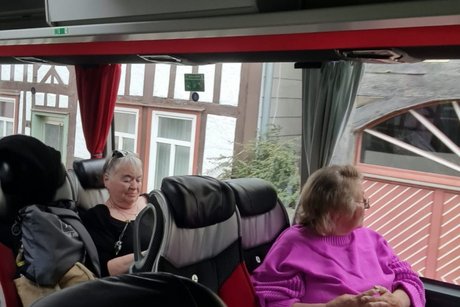 Zwei Personen sitzen in einem Reisebus