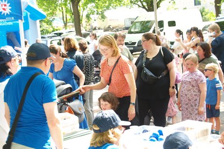 Mehrere Eltern und Kinder stehen am VdK-Stand und versuchen sich beim Spiel &bdquo;Entenangeln&ldquo;