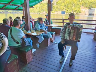 Ein Akkordeonspieler an Deck des Floßes