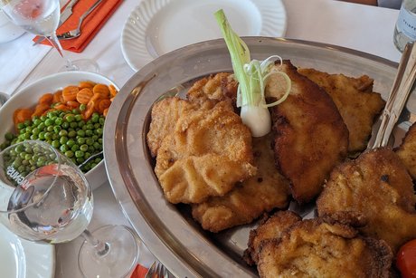 Servierplatte mit mehreren Schnitzeln. Danaben eine Schale mit Mischgem&uuml;se