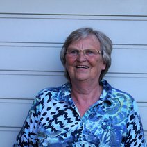 Eine &auml;ltere Frau mit blonden Haaren, Brille und einer gemusterten Bluse