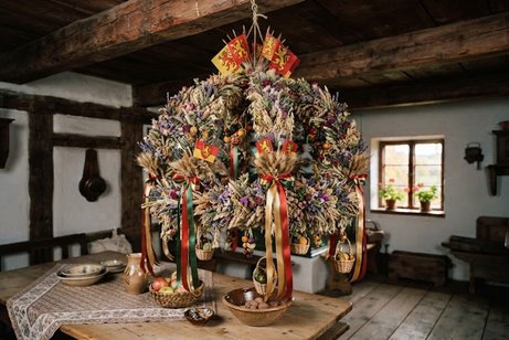 Eine gro&szlig;e und sch&ouml;n geschm&uuml;ckte Erntekrone h&auml;ngt in einem alten Fachwerkhaus.