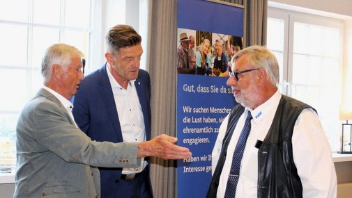 Die drei Männer begrüßen sich