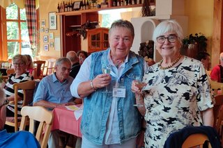 Jutta Da Corte und Karin Müller stehen mit einem Sektflas in der Hand zusammen