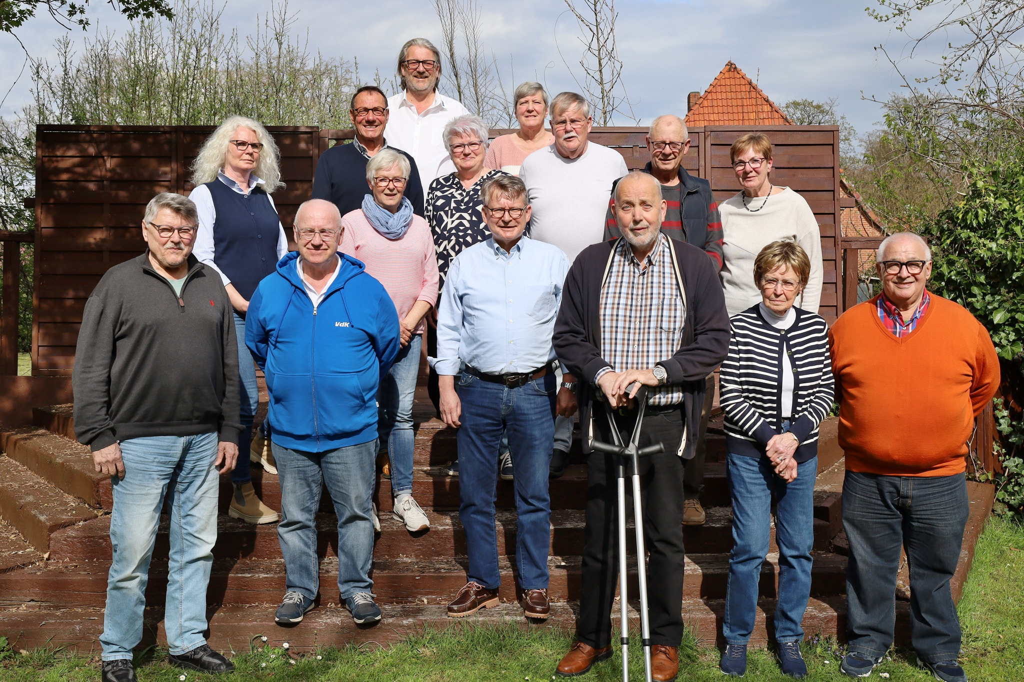 Der Vorstand des VDK KV Celle steht im Fr&uuml;hling vor einem h&ouml;lzernen Zaun.