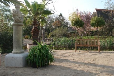 Bild vom Garten des Arboretum mit Palme und Steinstatur