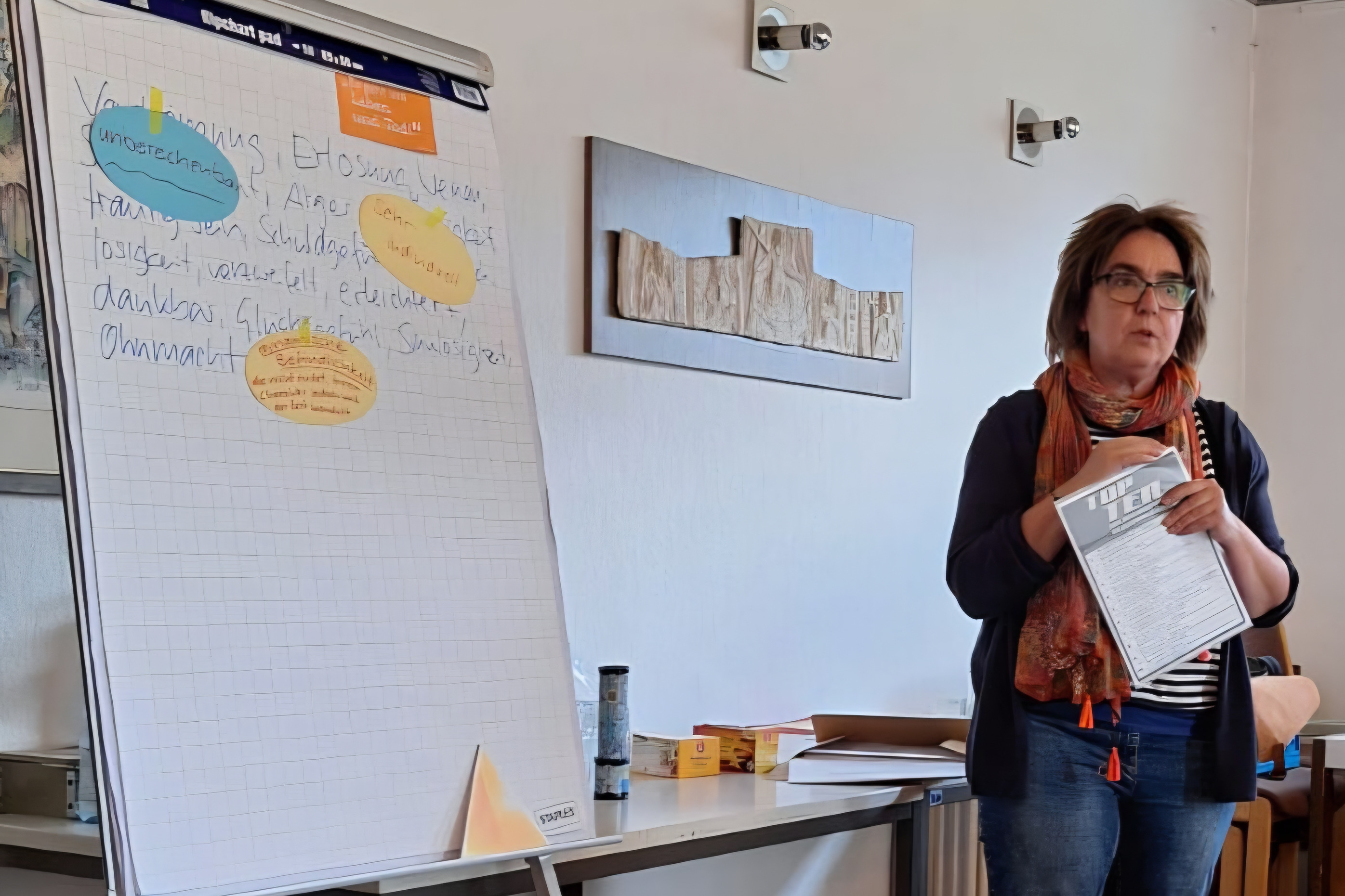 Frau Beate Hager steht vor den Zuh&ouml;rern neben einem Flipchart