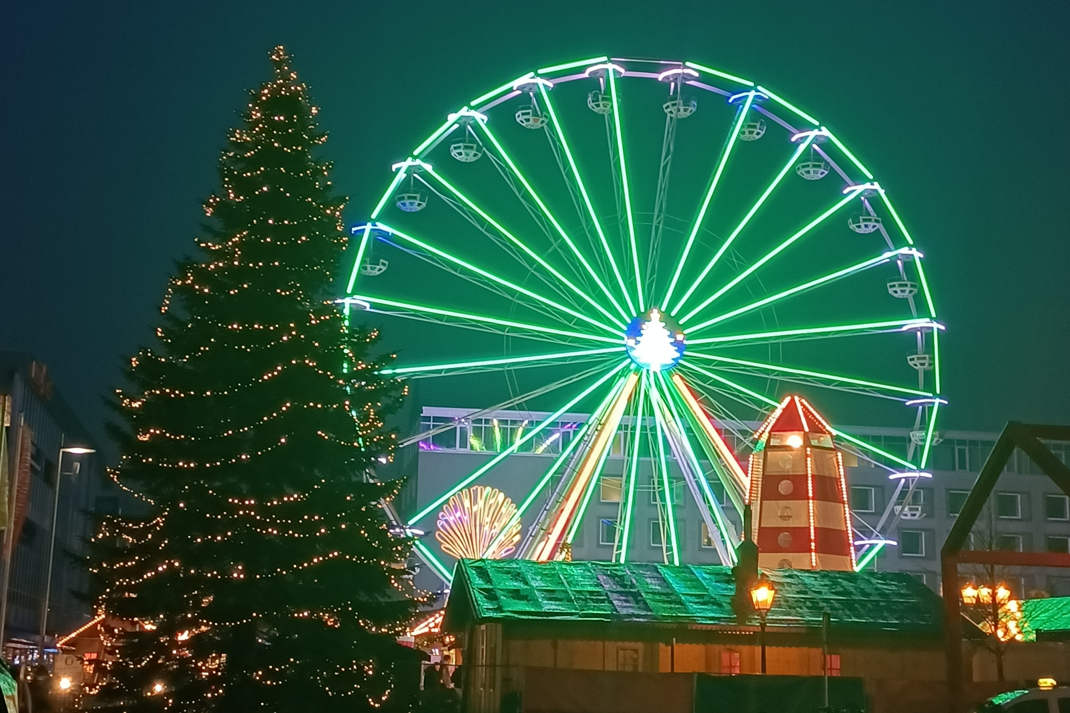 Weihnachtsmarkt mit Riesenrad und beleuchtetem Weihnachtsbaum Weihnachtsmarkt mit Riesenrad und beleuchtetem Weihnachtsbaum