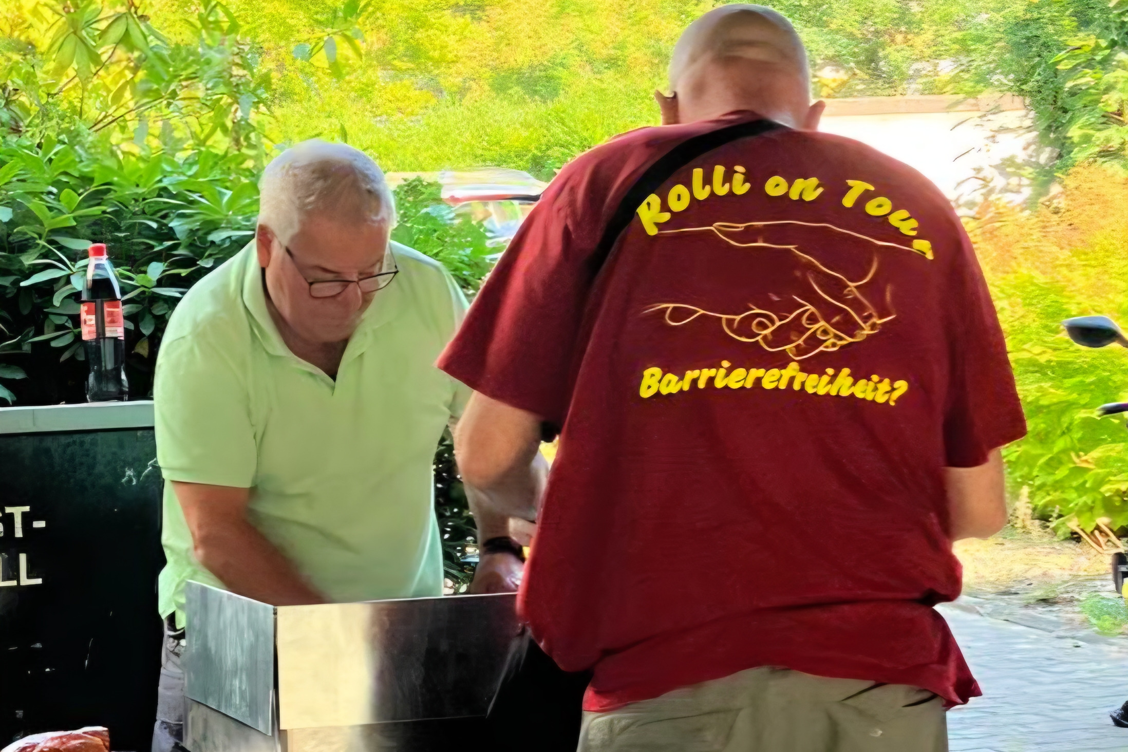 zwei M&auml;nner stehen am Grill