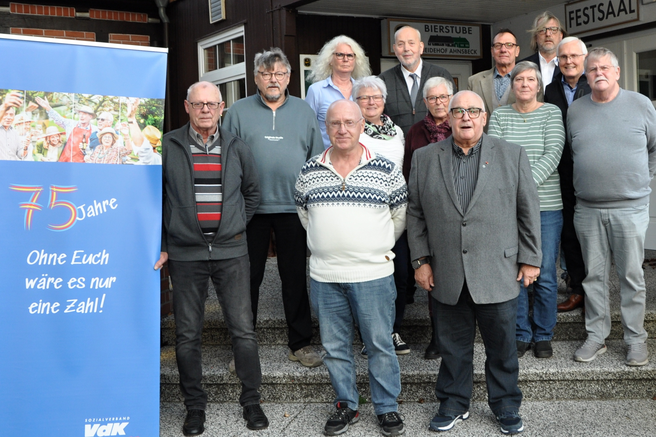 Auf dem Foto ist der neue Kreisvorstand Celle zu sehen. Der Vorstand steht vor dem Lokal in Ahnsbeck auf der Treppe. Vorne links ist der Banner des VdK zu sehen. Hinten rechts stehen Matthias Krüger und Gerhard Skradde