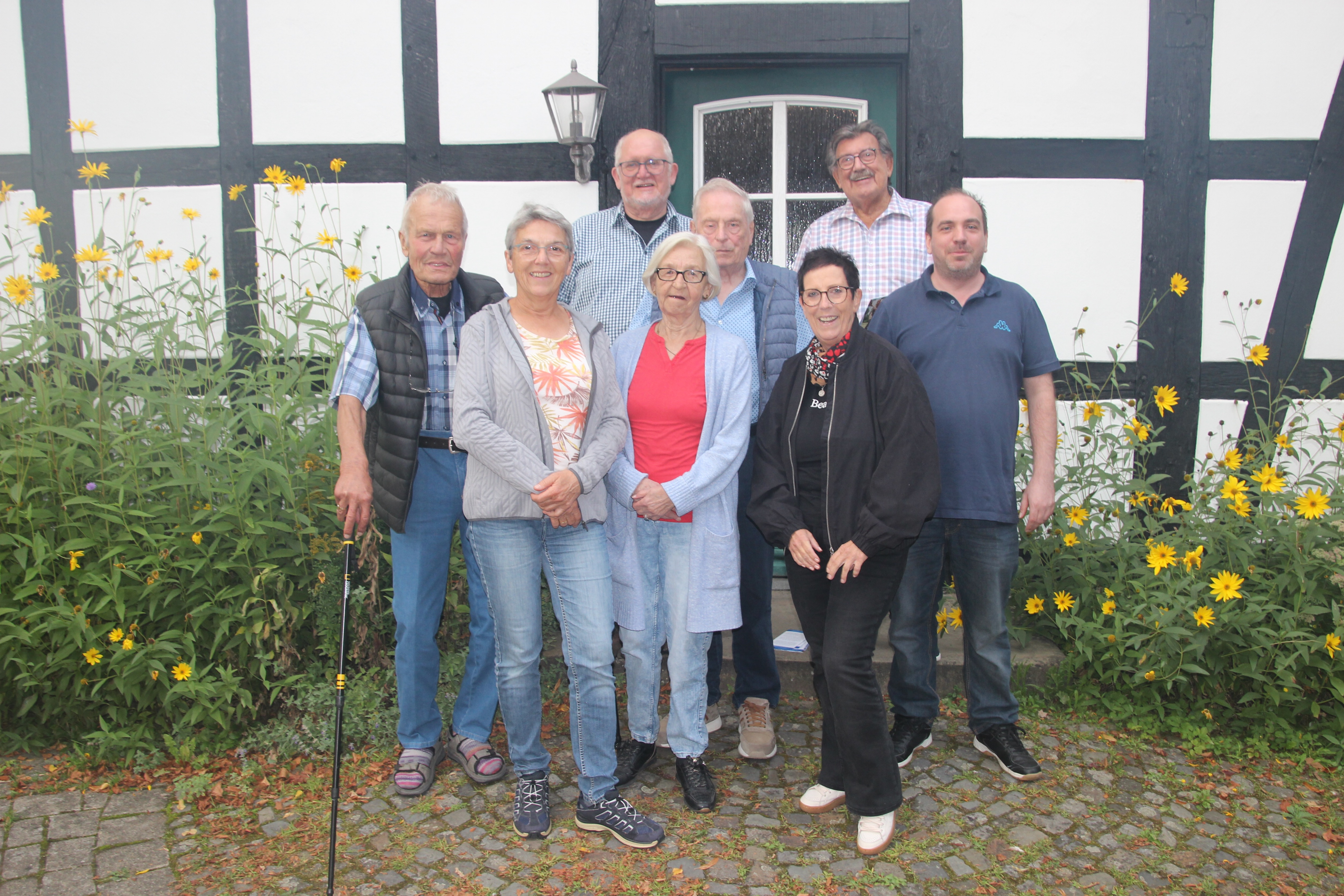 die Mitglieder des Vorstandes und die Kassenprüfer vor einem Fachwerkhaus des Dorfplatzes Hüsede